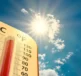 Guide de survie estival – gérer efficacement les crampes liées à la chaleur – image montrant un ciel bleu avec de gros nuages blancs et le soleil brillant en arrière-plan, avec un thermomètre indiquant des températures élevées typiques de l’été.